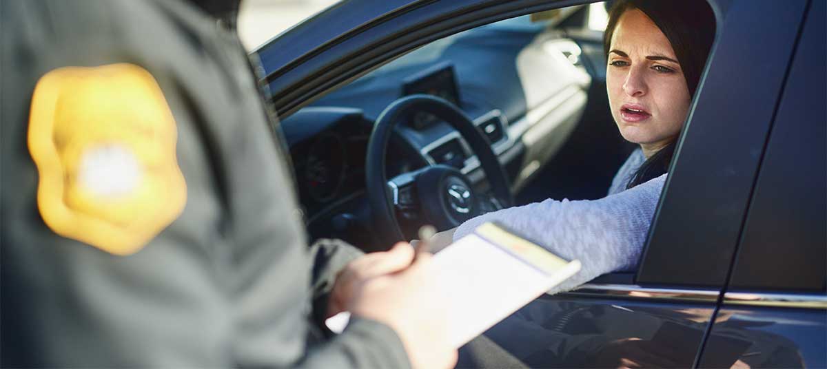 A police officer pulling over a worried driver during a traffic stop, representing DUI Legal Representation Charlevoix services.