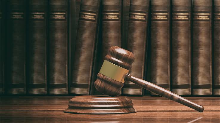 A wooden gavel and sounding block in front of a row of law books, representing DWI Lawyer Gaylord MI services.