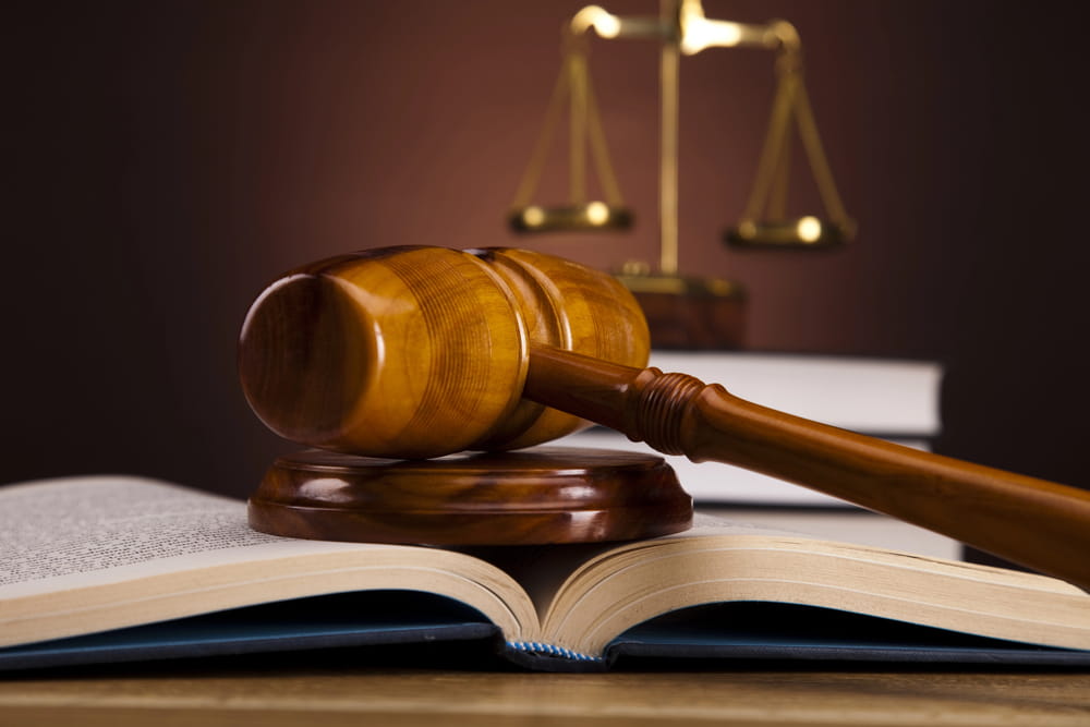 A wooden gavel resting on an open law book with scales of justice in the background, representing DWI Lawyer Gaylord MI services.