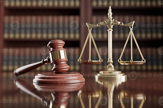 A wooden gavel resting on its sound block beside brass scales of justice in a law office setting, symbolizing legal proceedings for an owi causing injury charge.
